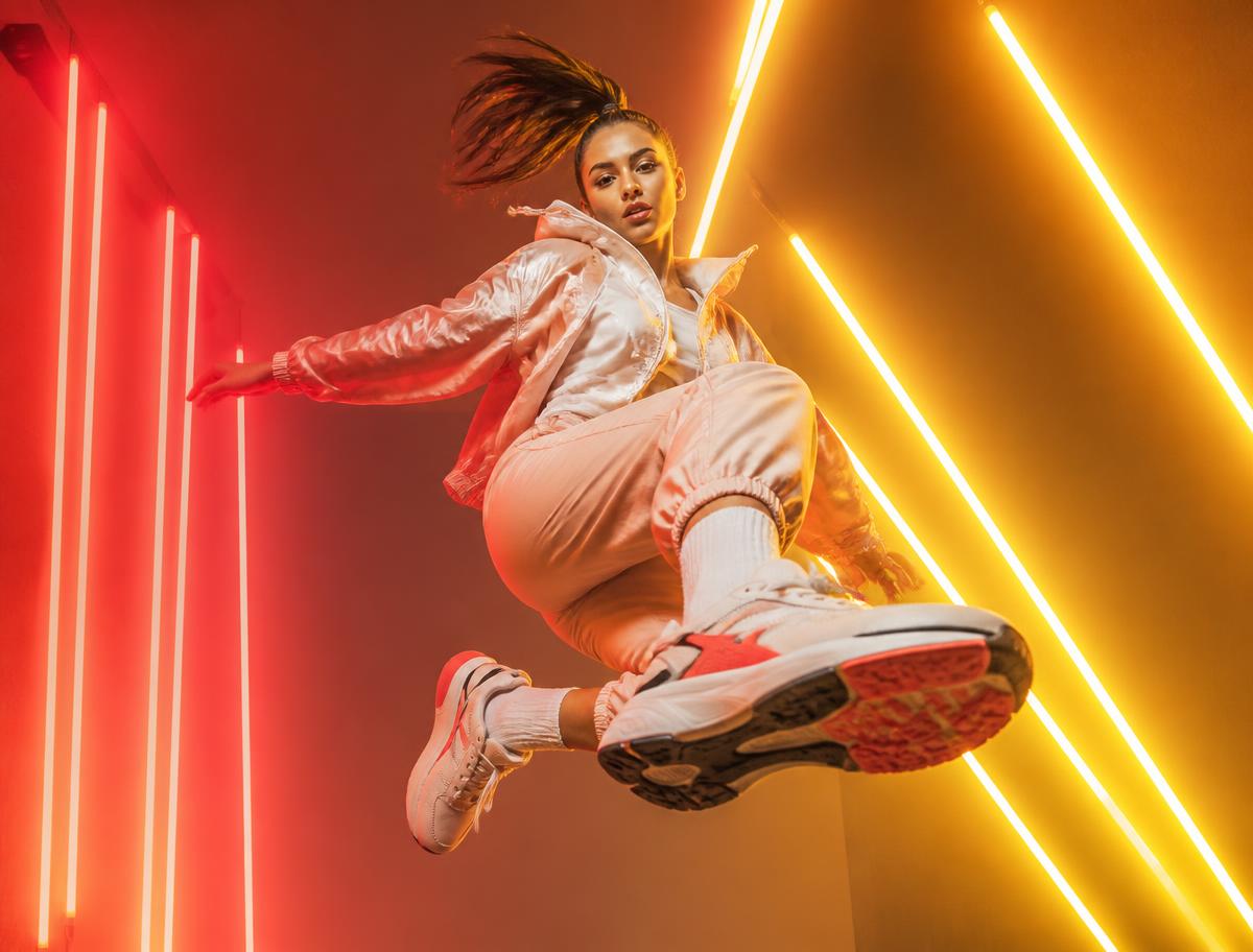Neon fashion campaign featuring a model in motion